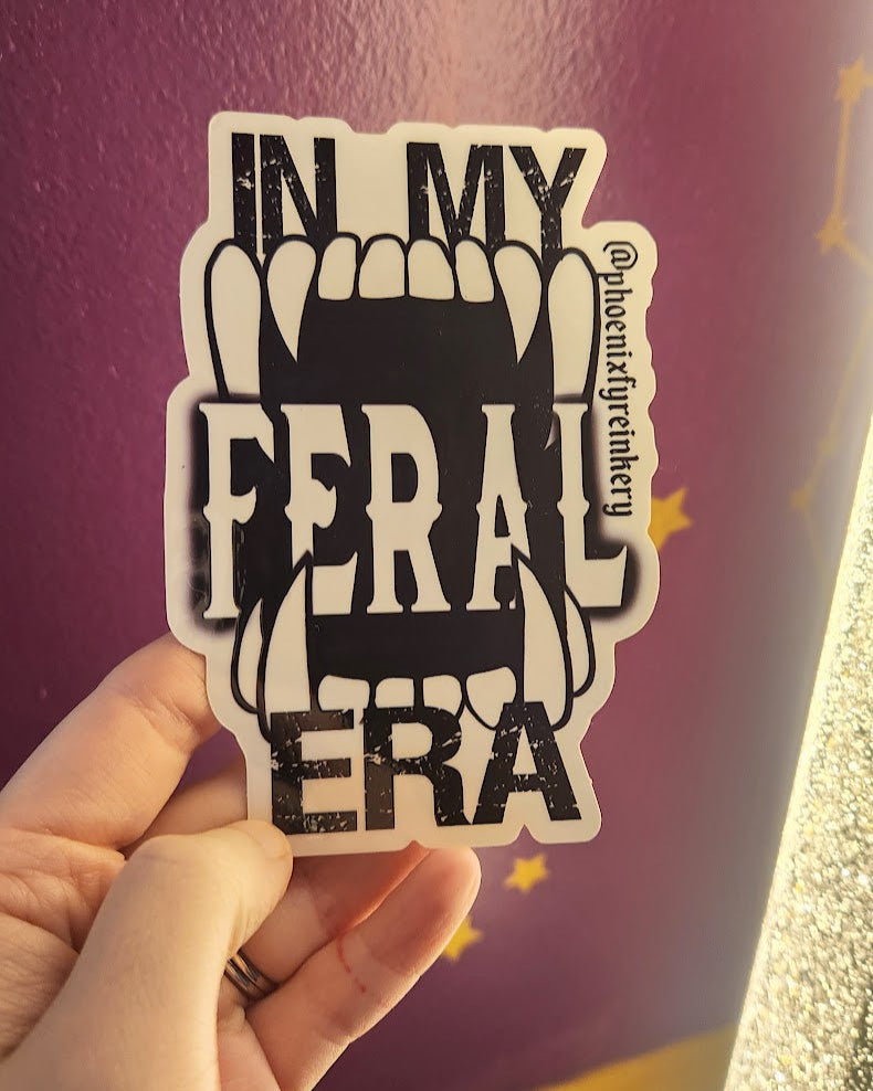 Hand holding a black and white sticker with text against a purple background